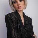 Fashion model with short blonde bob wig in black lace outfit.